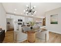 Stylish kitchen with white cabinets, stainless steel appliances, and a glass table in the dining area at 6388 Canyon Dawn Ave, Las Vegas, NV 89108