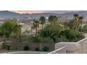 A backyard with lush greenery and a view of the city skyline and mountain range at 6999 Stone Meadows Ave, Las Vegas, NV 89142