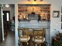 Stylish home bar featuring a glass shelf, designer backsplash, and seating for entertaining guests at 7400 Amigo St, Las Vegas, NV 89123