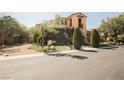 Inviting two-story home with manicured lawn, mature trees, and stone accents at 7947 Lookout Rock Cir, Las Vegas, NV 89129
