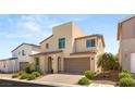 Inviting exterior featuring an arched doorway, two-car garage, and desert-friendly landscape at 812 Stannard Ct, Henderson, NV 89052