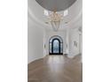 Elegant foyer featuring herringbone wood floors, decorative chandelier, and arched entryways at 8130 Cassian Ct, Las Vegas, NV 89129