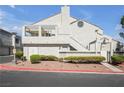Charming stucco condo with a private balcony, red rock landscaping, and a lovely front yard at 8932 Antioch Way, Las Vegas, NV 89117