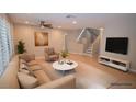 Bright living room with a comfortable beige sofa, chair, and stylish decor, virtually staged at 9408 Amber Valley Ln, Las Vegas, NV 89134