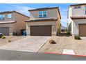 Featuring a spacious two-car garage with a paved driveway and drought tolerant landscaping at 1023 Brilliant Meadow Ave, North Las Vegas, NV 89086