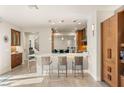 Open-concept kitchen boasts a breakfast bar with sleek stools and modern lighting fixtures at 11398 Belmont Lake Dr # 104, Las Vegas, NV 89135