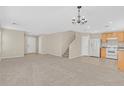 Open-concept living room with neutral carpet that flows seamlessly into the adjacent kitchen at 11934 Wild Chamomile St, Las Vegas, NV 89183
