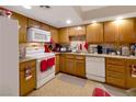 Galley kitchen with wood cabinets, granite countertops, and white appliances at 1312 Rawhide St, Las Vegas, NV 89119