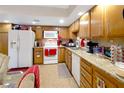Galley kitchen with wood cabinets, granite countertops, and white appliances at 1312 Rawhide St, Las Vegas, NV 89119