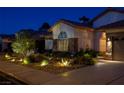 Beautiful single story home with stone accents and desert landscaping illuminated at night at 1432 Castle Crest Dr, Las Vegas, NV 89117