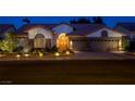 Inviting single-story home at night featuring desert landscaping, a tile roof, and a stucco exterior at 1432 Castle Crest Dr, Las Vegas, NV 89117