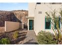 Inviting entryway featuring a bright teal door, manicured landscaping, and a paved walkway at 350 Solitude Peak Ln, Henderson, NV 89012