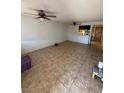 Spacious living room with neutral tile flooring, ceiling fans, and an open layout leading to the kitchen at 3585 Arville St # 401A, Las Vegas, NV 89103