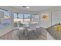 Bright dining area featuring a modern round table, white chairs, and sliding glass doors to the backyard at 3604 N Campbell Rd, Las Vegas, NV 89129