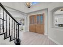 Inviting foyer with stylish light wood floors and an elegant staircase with black railing and decorative front door at 3604 N Campbell Rd, Las Vegas, NV 89129