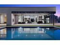 Backyard featuring a private pool reflecting the lights of the open concept living area at 38 Skybird Ct, Las Vegas, NV 89135