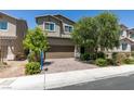 Inviting two-story home features a well-maintained front yard and a brick-paved driveway leading to a two-car garage at 4633 Fragrant St, North Las Vegas, NV 89031