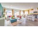 Open-concept living room with lots of natural light, island seating, and wood-look flooring at 505 Red Lovebird Ave # Lot 1229, Henderson, NV 89011