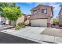 Exterior view of a two-story home featuring a spacious driveway, two-car garage, and desert landscaping at 5321 Welch Valley Ave, Las Vegas, NV 89131