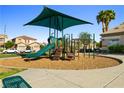 Community playground with slide, shade structure, and views of neighborhood homes at 5456 Raccoon Valley Ln, Las Vegas, NV 89122