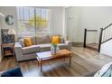 Bright living room features a comfortable sofa, wood-look floors, and a large window at 5733 Coral Sun St, North Las Vegas, NV 89031