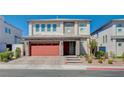 A charming two-story home with a paver driveway and a red two-car garage at 6790 Tangled Vines Ave, Las Vegas, NV 89139