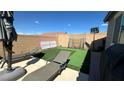 Backyard with lounge chairs, basketball hoop and netting with artificial grass at 716 Cadence View Way, Henderson, NV 89011