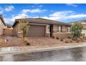 Charming single-story house with a well-manicured front yard and brick-paved driveway leading to the garage at 741 Monroe Hill Pl, Henderson, NV 89011
