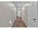 Bright hallway with wood-look flooring and white doors offering a modern and clean aesthetic at 741 Monroe Hill Pl, Henderson, NV 89011