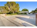 Expansive driveway leading to a charming ranch-style home with mature landscaping, offering ample parking at 7545 Constantinople Ave, Las Vegas, NV 89129