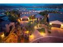 Stunning exterior view of a luxury home with brick driveway, professional landscaping, and lake view at 8 Laricola Ct, Henderson, NV 89011