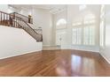 A grand living room features wood floors, staircase, high ceilings and multiple windows with shutters at 8205 Taos Paseo Ave, Las Vegas, NV 89128