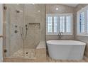 The bathroom features a glass-enclosed shower, soaking tub, and white shuttered window at 8437 Apple Hill Ct, Las Vegas, NV 89128