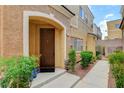 Charming front entrance with a solid door, manicured landscaping, and a well-lit pathway at 9303 Gilcrease Ave # 1056, Las Vegas, NV 89149