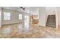 Spacious living room with tile flooring, natural light, and an open staircase at 9452 Plover Falls Ave, Las Vegas, NV 89149
