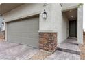 Close up of home showcasing a two-car garage with stone accents and a paved walkway to the front door at 10836 Montana Blanca Ave, Las Vegas, NV 89166