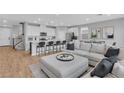 Bright, open-concept living area featuring a comfortable gray sectional sofa and kitchen with modern appliances at 10836 Montana Blanca Ave, Las Vegas, NV 89166