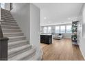 Open-concept layout with staircase, hardwood flooring, and abundant natural light from the multiple windows at 10836 Montana Blanca Ave, Las Vegas, NV 89166
