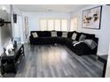 Spacious living room features modern gray flooring and a large, comfortable black sectional sofa at 1482 Flintrock Rd, Henderson, NV 89014