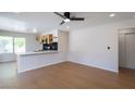 Open-concept living room featuring wood floors, modern ceiling fan, and a breakfast bar with updated kitchen at 1878 Corvette St, Las Vegas, NV 89142