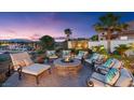 Cozy outdoor seating area with a stone fire pit, comfortable seating, and views of the lake at 20 Via Paradiso St, Henderson, NV 89011