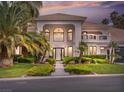 Stunning home featuring a well-manicured lawn, beautiful landscaping, and a decorative driveway at sunset at 21 Sawgrass Ct, Las Vegas, NV 89113