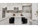 Modern kitchen with white cabinets, stainless steel appliances, a beautiful island, and plenty of counter space at 21 Sawgrass Ct, Las Vegas, NV 89113