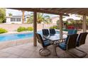 Outdoor dining area on a covered patio, overlooking a sparkling pool and a beautifully landscaped backyard at 2383 Thayer Ave, Henderson, NV 89074