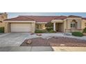 Inviting single-story home with a spacious driveway, two-car garage, and desert-style landscaping at 2829 Golf Links Dr, Las Vegas, NV 89134