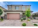 Charming two-story home showcasing a well-manicured front yard and a two-car garage with brick-paved driveway at 361 Cooper Hawk Ct, Las Vegas, NV 89138