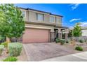 Charming two-story home showcasing a well-manicured front yard and a two-car garage with brick-paved driveway at 361 Cooper Hawk Ct, Las Vegas, NV 89138