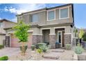 Charming two-story home showcasing a well-manicured front yard with desert landscaping and a covered porch at 361 Cooper Hawk Ct, Las Vegas, NV 89138