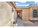 Close up of a home's front door with side window, concrete walkway and gravel landscaping at 503 Credence Ave, Henderson, NV 89002