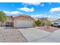 Shot of a two-car garage with adjacent gate, gravel yard, and concrete driveway in front at 503 Credence Ave, Henderson, NV 89002